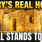 Ancient stone house traditionally associated with the Virgin Mary, preserved inside a grand basilica and bathed in warm golden sunlight, with a crowned statue of Mary in prayer and bold text reading “MARY'S REAL HOME – STILL STANDS TODAY.”